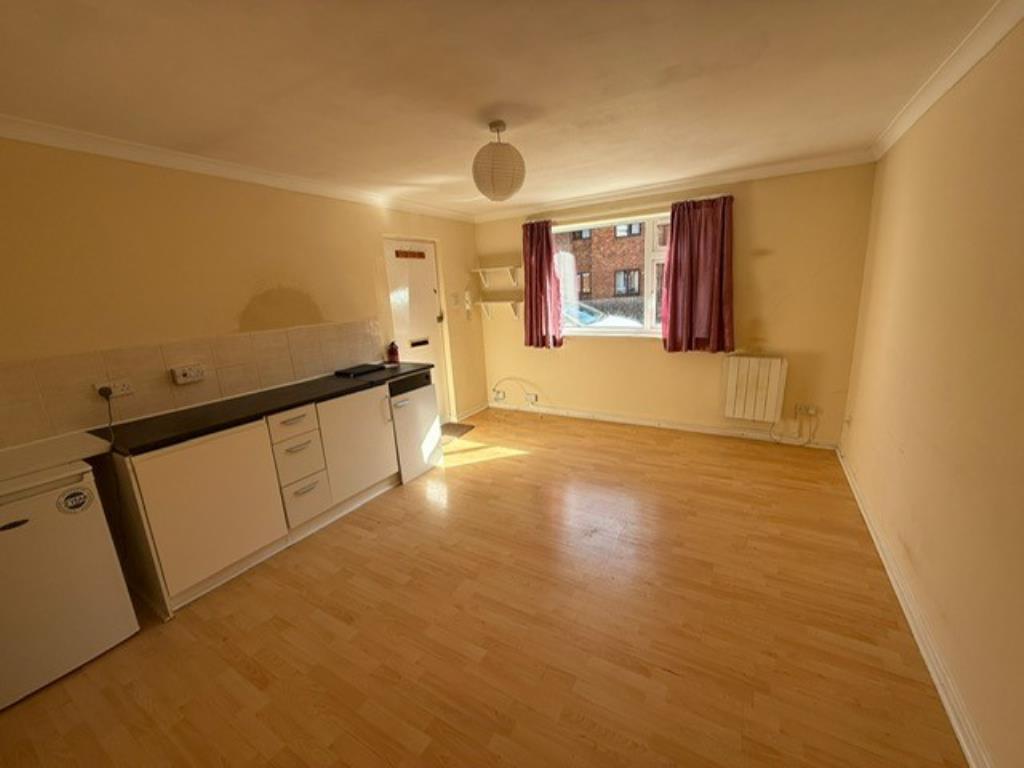 Lot: 121 - GROUND FLOOR APARTMENT FOR IMPROVEMENT - Living room view showing kitchenette and window